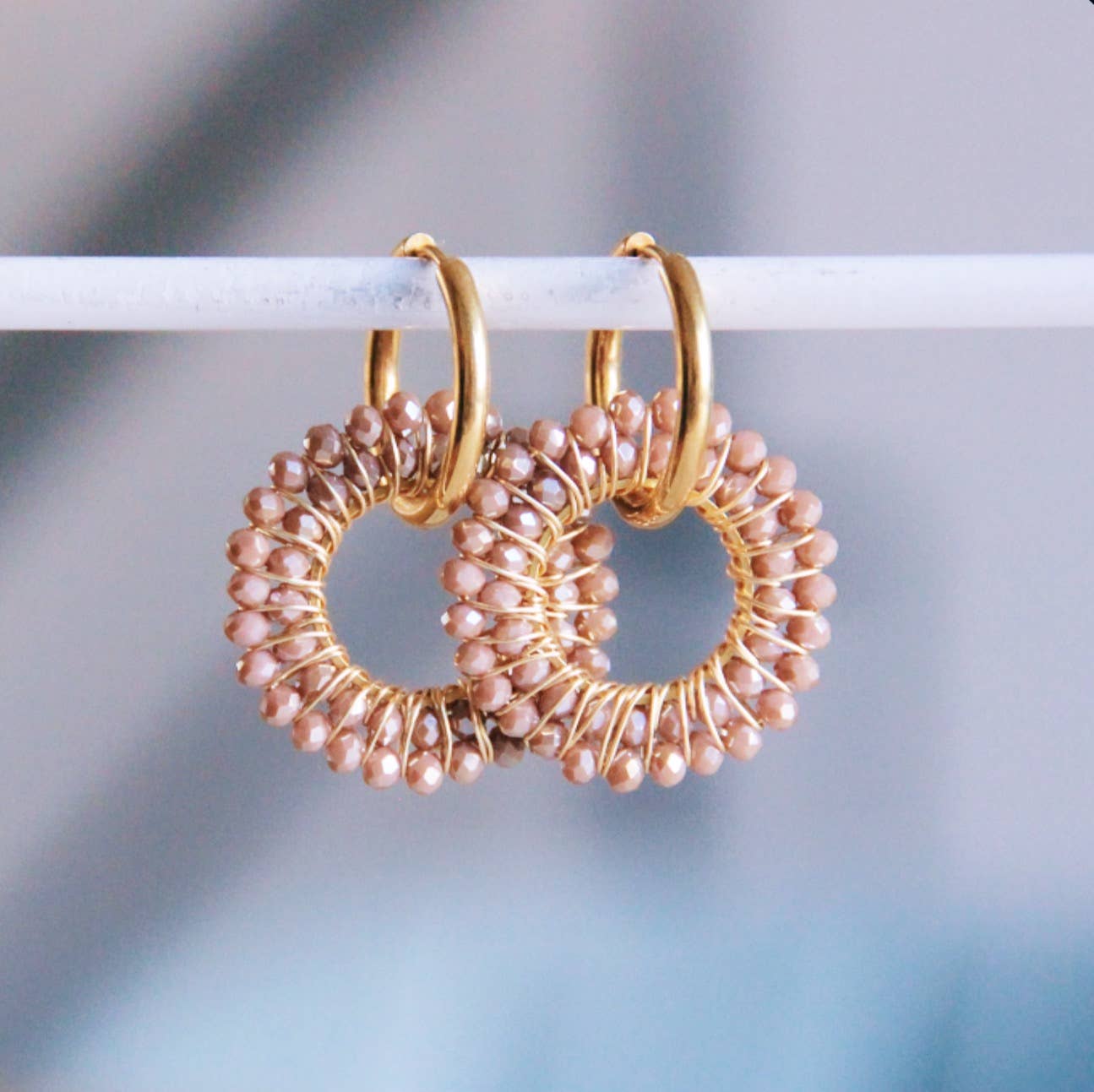 Ronde roestvrijstalen oorbellen met goudkleurige kralen. Gouden oorringen met kleine roze parels, elegante sieraden.