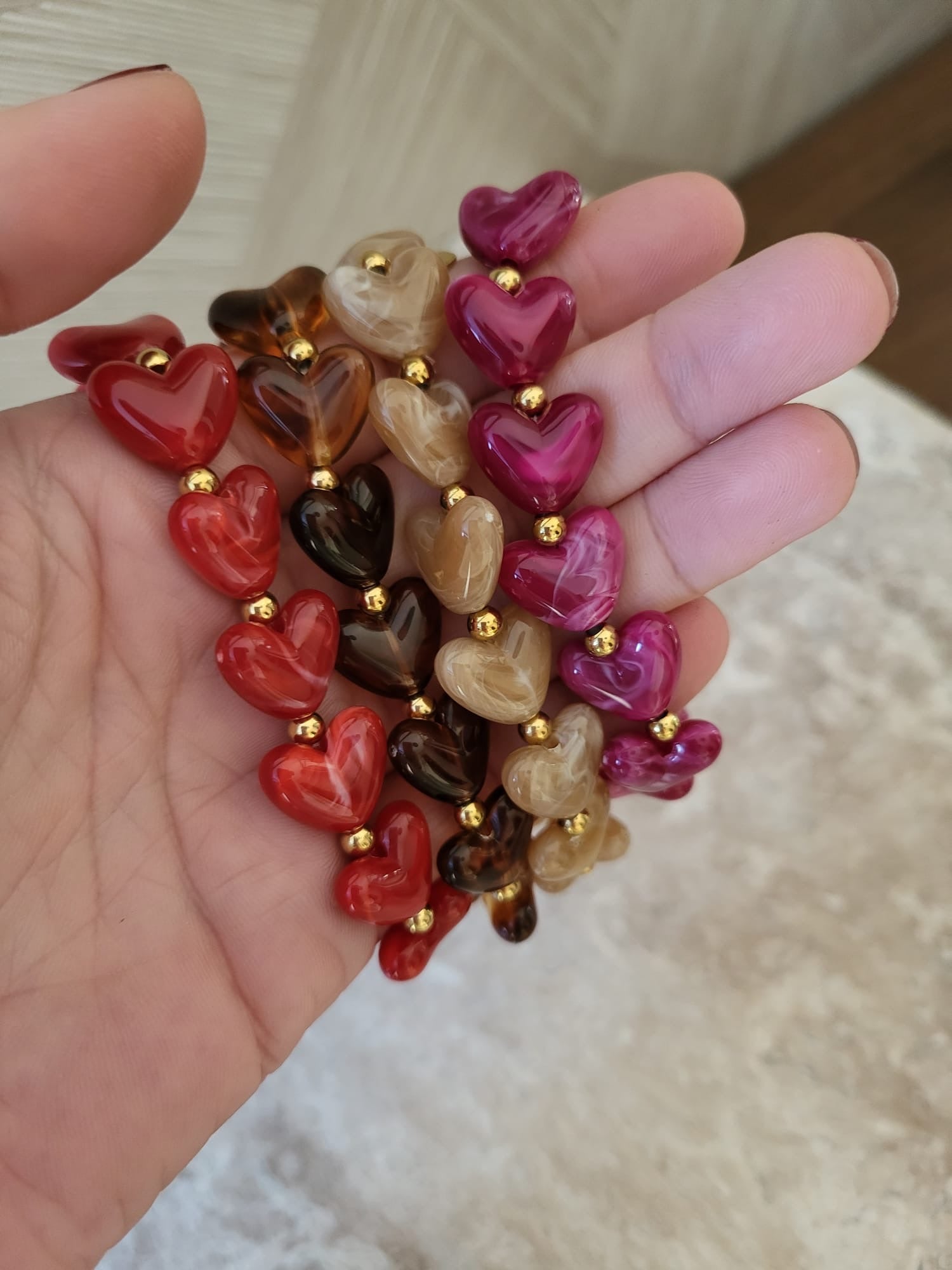 Milena hartjes armband in rood, bruin en roze met gouden kralen, gemaakt van roestvrij staal.