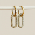 Glanzende Lumina oorbellen met sprankelende zirkonia stenen, gemaakt van goudkleurig stainless steel. Luxe dames oorhangers.