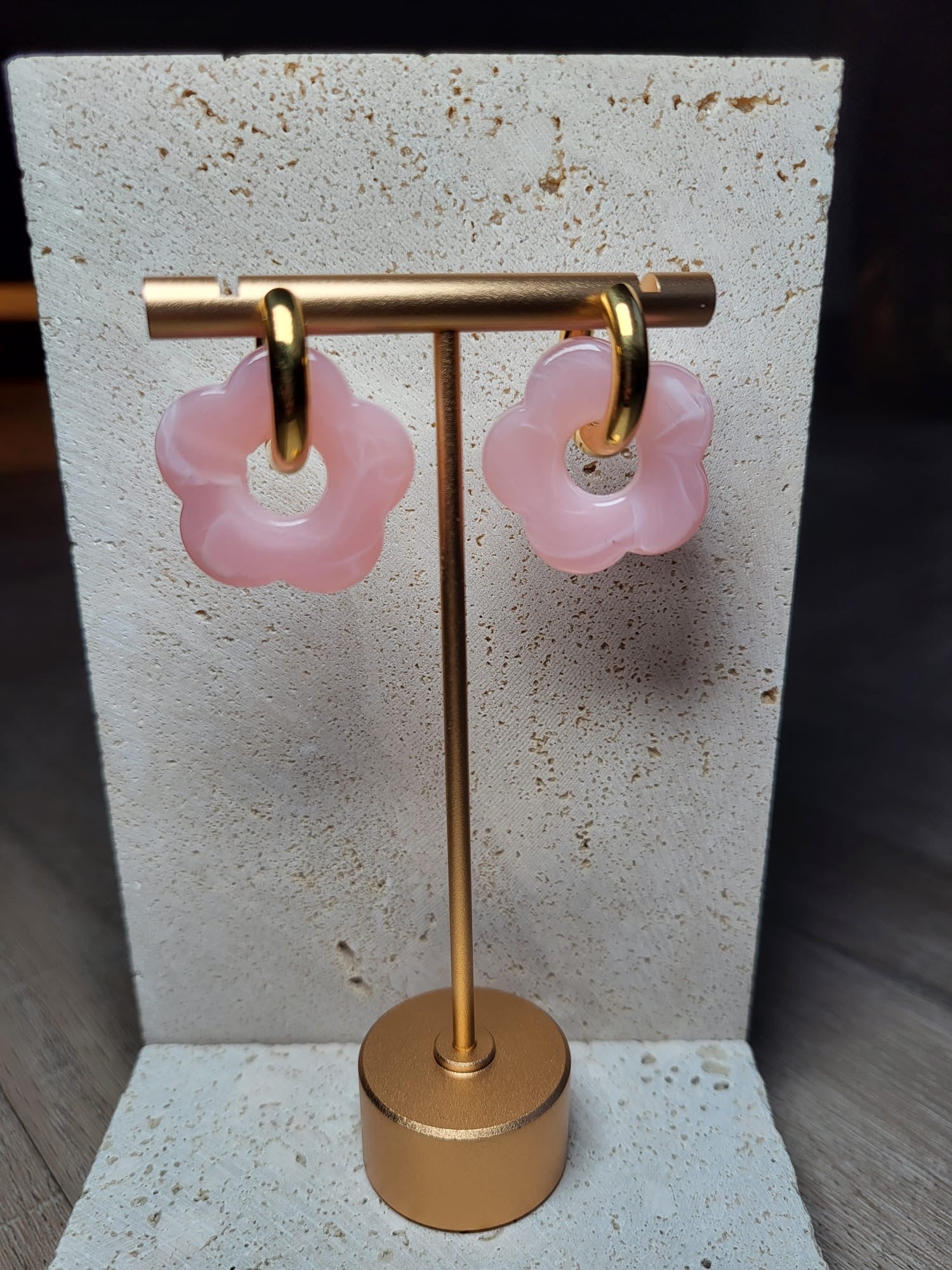 Roze oorbellen in de vorm van bloemen, hangend aan een gouden standaard, perfect voor een elegante look.