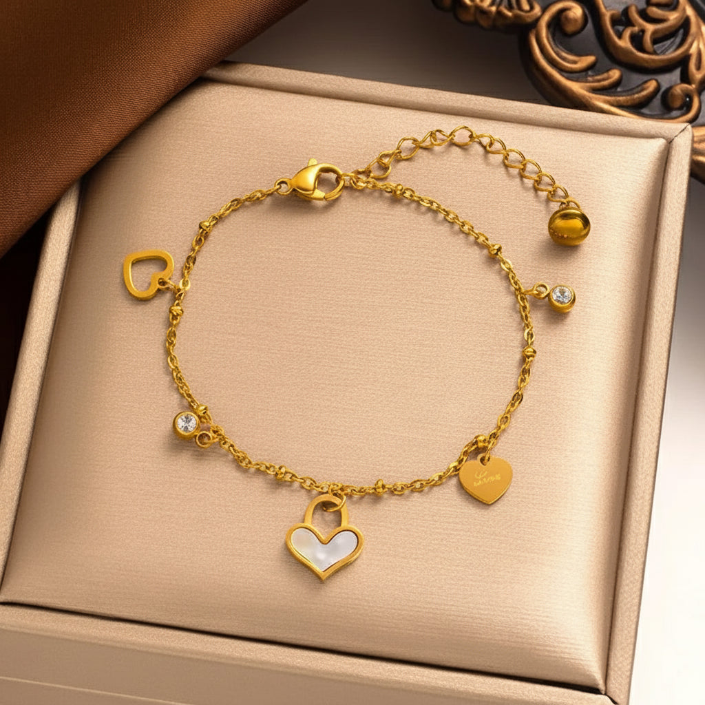 Gouden armband van roestvrij staal met hartjesbedels, glimmende steentjes en verstelbare sluiting. Elegant dames sieraad.