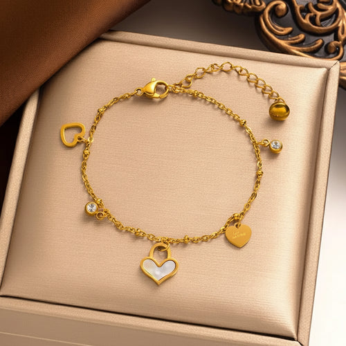 Gouden armband van roestvrij staal met hartjesbedels, glimmende steentjes en verstelbare sluiting. Elegant dames sieraad.