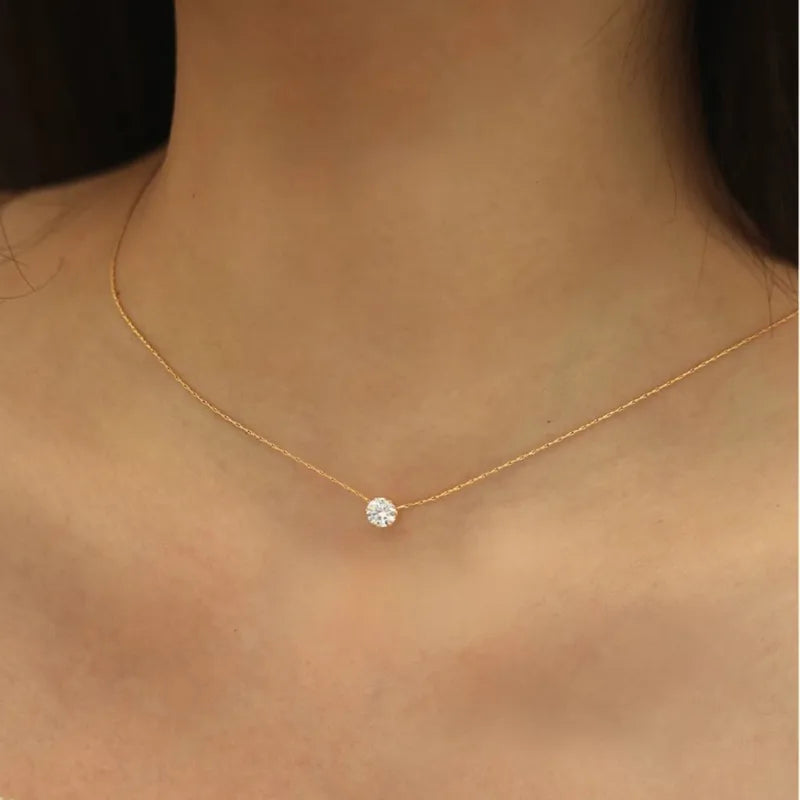 Goudkleurige stainless steel ketting met stralende zirkoon hanger op de hals, elegante Aurelia dames sieraad
