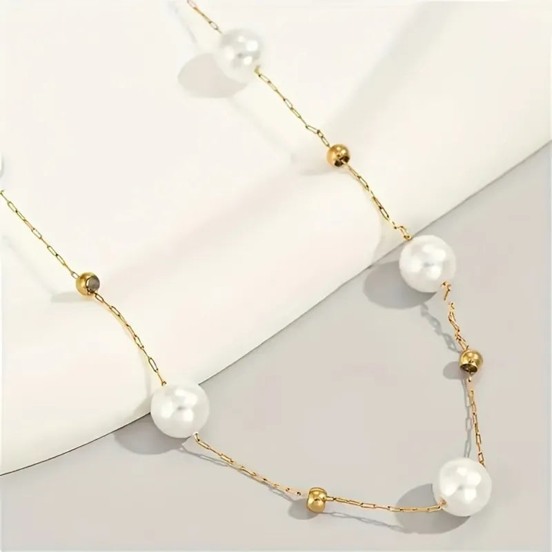 Goudkleurige ketting met witte imitatie parels en gouden kralen, geschikt voor dames.