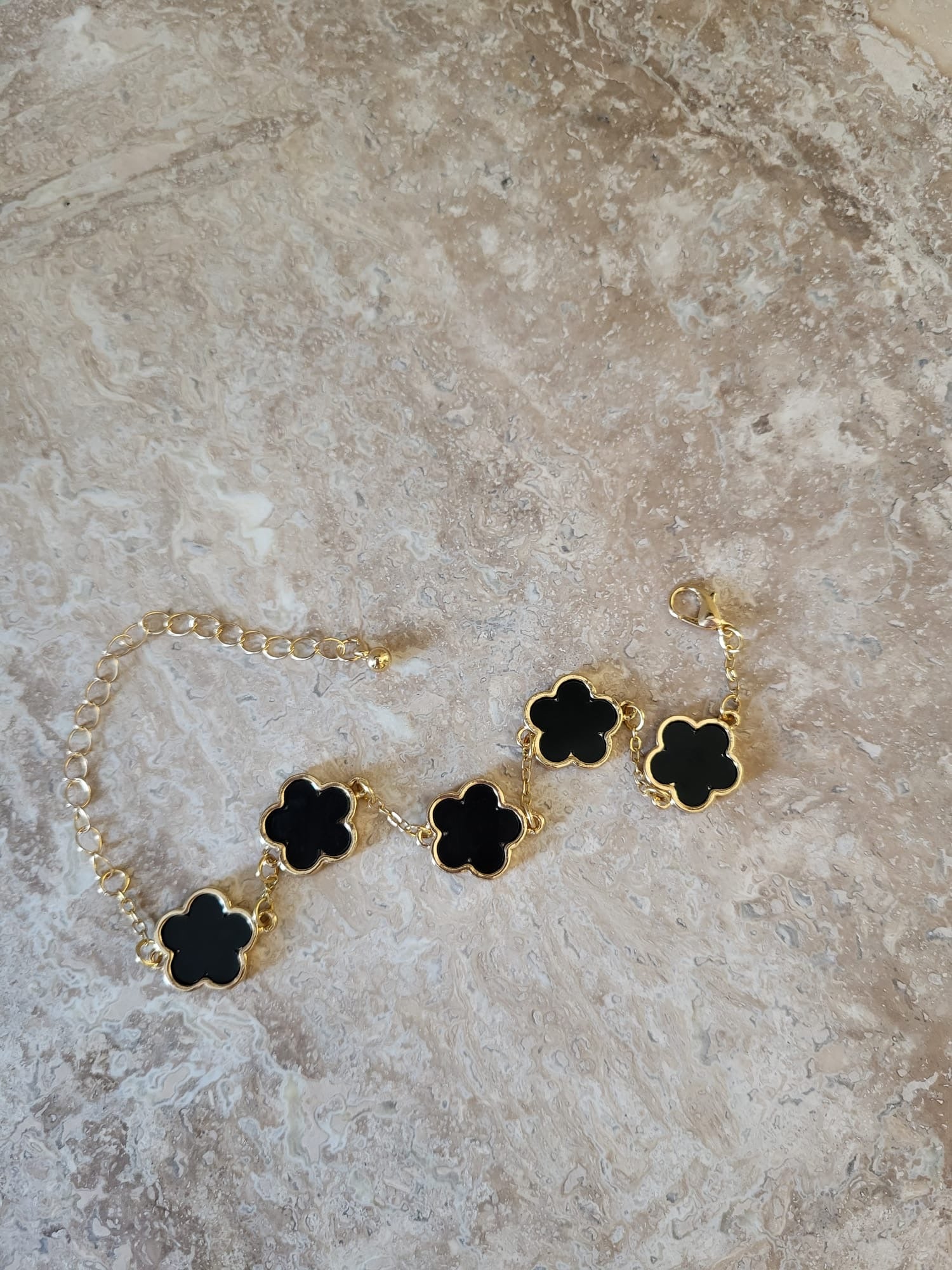 Belle zwarte armband van roestvrij staal met goudkleurige ketting en vier klavertjes vier bedels
