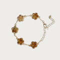 Gouden Belle armband met bloemvormige schakels en bruine hars details, gemaakt van roestvrij staal.