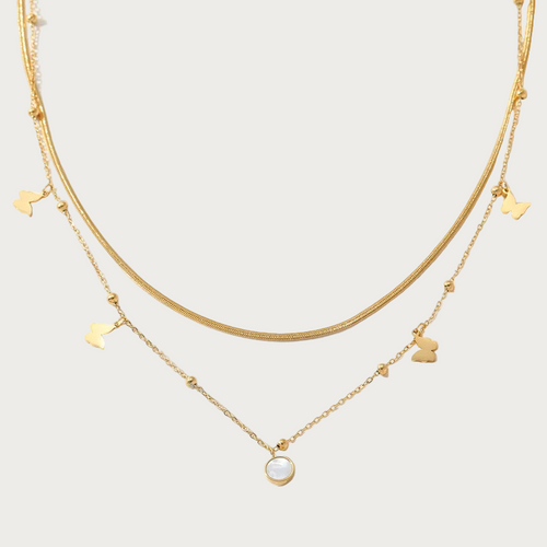 Gouden dubbele ketting van stainless steel met vlinder bedels en een ronde parelmoer hanger, elegant dames sieraad