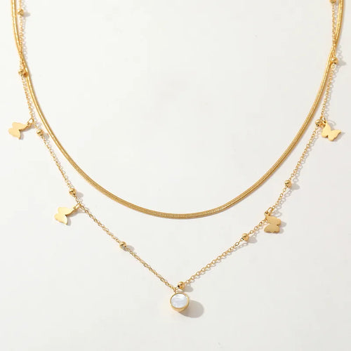 Gouden dubbele ketting van roestvrij staal met vlinder bedeltjes en een ronde schelpmotief hanger.