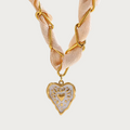 Celeste ketting met beige lint, gouden schakels, en hartvormige hanger van roestvrij staal