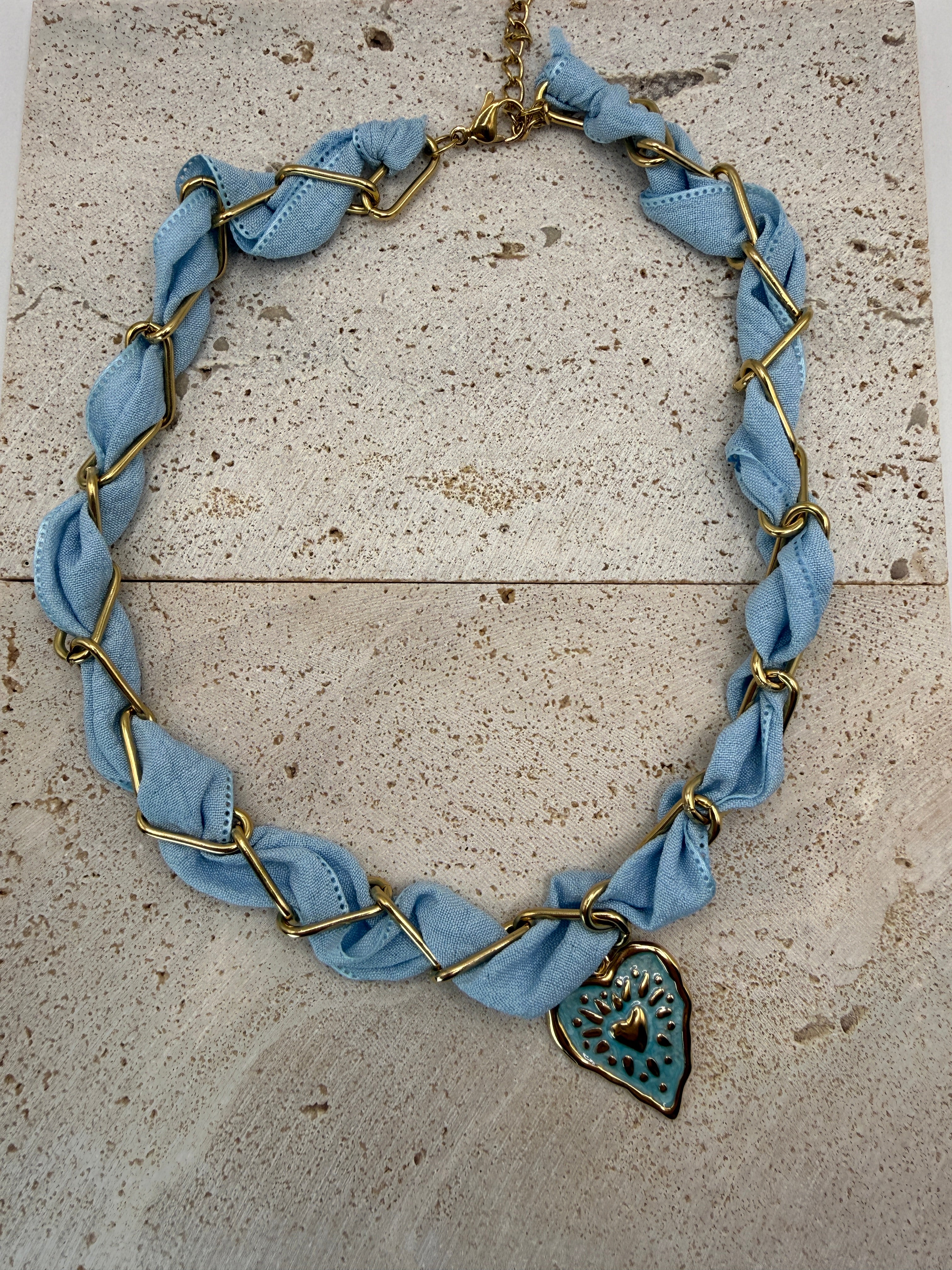 Celeste blauwe ketting van roestvrij staal met gouden hart hanger, ingevlochten textiel sieraden accessoire dames mode.