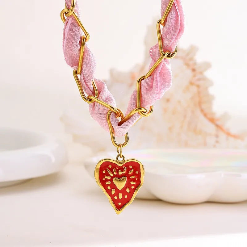 Celeste roze ketting met gouden schakels, rood hartbedeltje, gemaakt van duurzaam roestvrij staal.