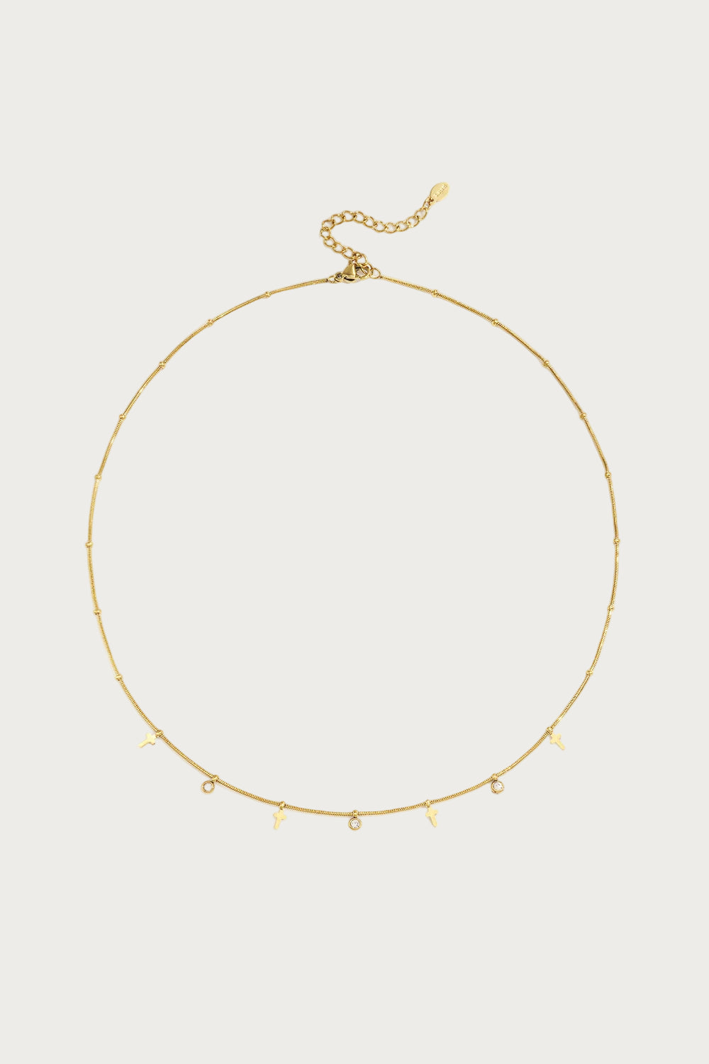 Goudkleurige stainless steel ketting met fijne schakels en hangerdetails, waaronder sleutels en strass steentjes