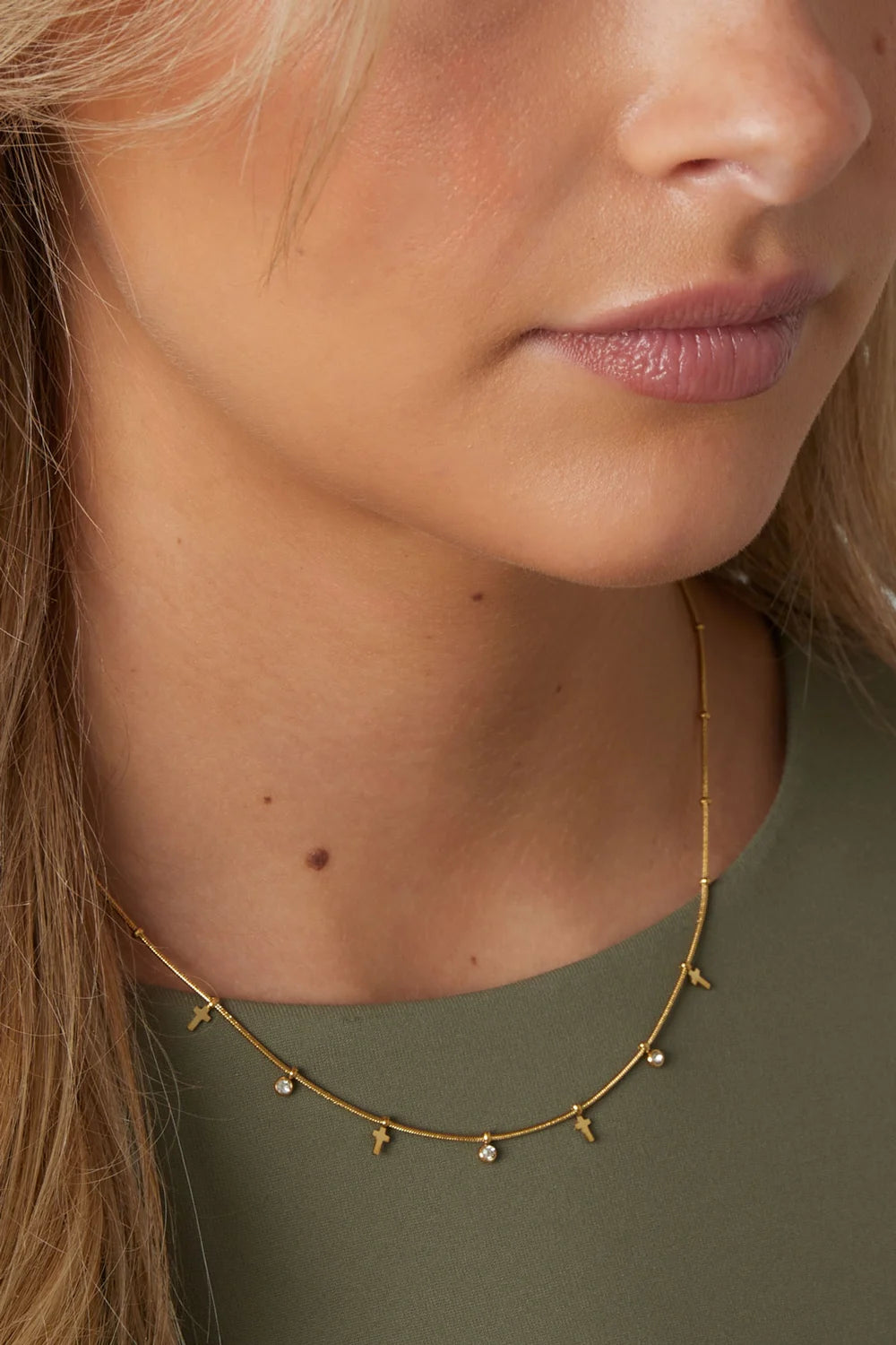 Gouden stainless steel ketting met kruisjes en zirkonia hangertjes.