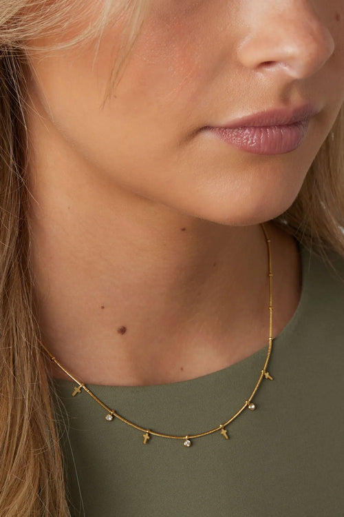 Gouden stainless steel ketting met kruisjes en zirkonia hangertjes.