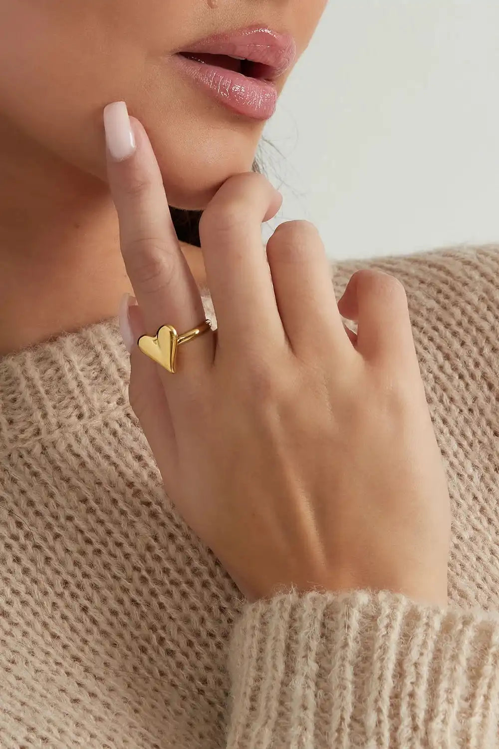 Gouden roestvrijstalen ring met elegant hartje aan vinger van model, Classy Heart ring sieraad accessoire.