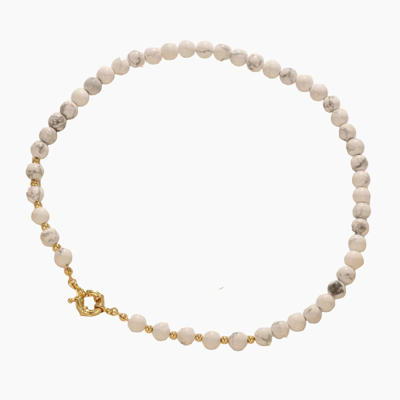 Elara kralenketting van natuursteen met witte howliet kralen en goudkleurige sluiting, modern dames sieraad