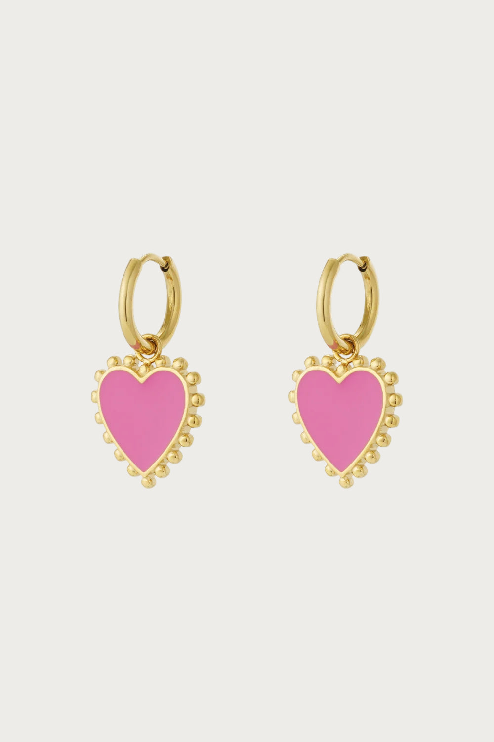Goudkleurige oorbellen met roze hartjes aan stevige rvs oorringen, funky sieraden van Mae