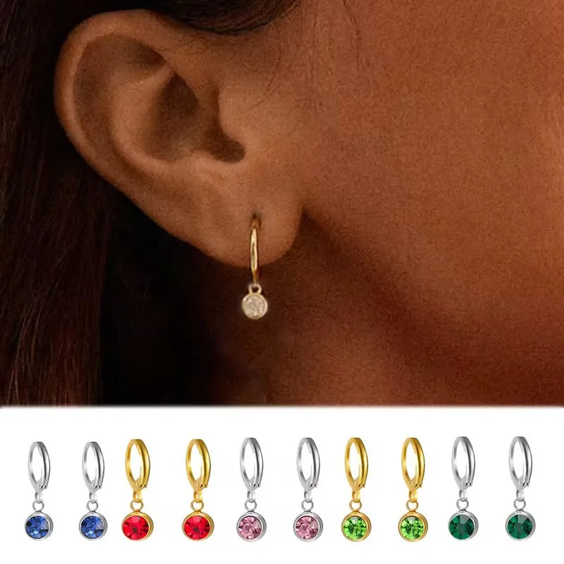 Gouden oorring met geboortesteen, model draagring, en een reeks van verschillende geboortesteen oorringen kleuren