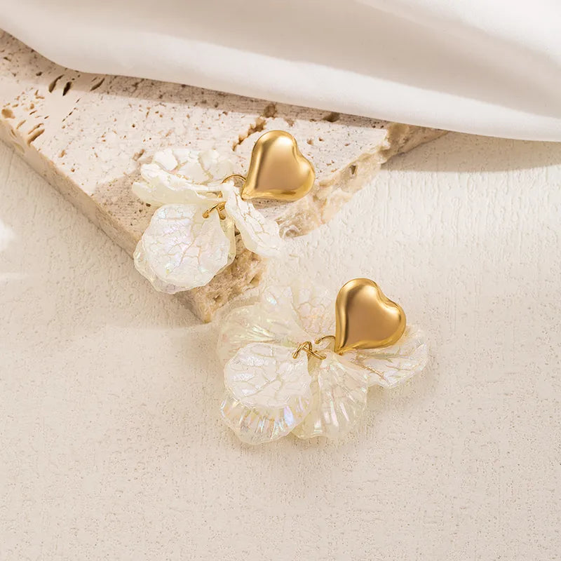 Stijlvolle Golden Bloom oorbellen van stainless steel met gouden hartjes en iriserende witte bloemblaadjes bloem.
