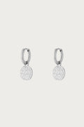 Horoscope Coin Silver Oorbellen van Jewellery by Mae met zilverkleurige stainless steel hoops en subtiele horoscoopbedel. Tijdloos en stijlvol ontwerp.