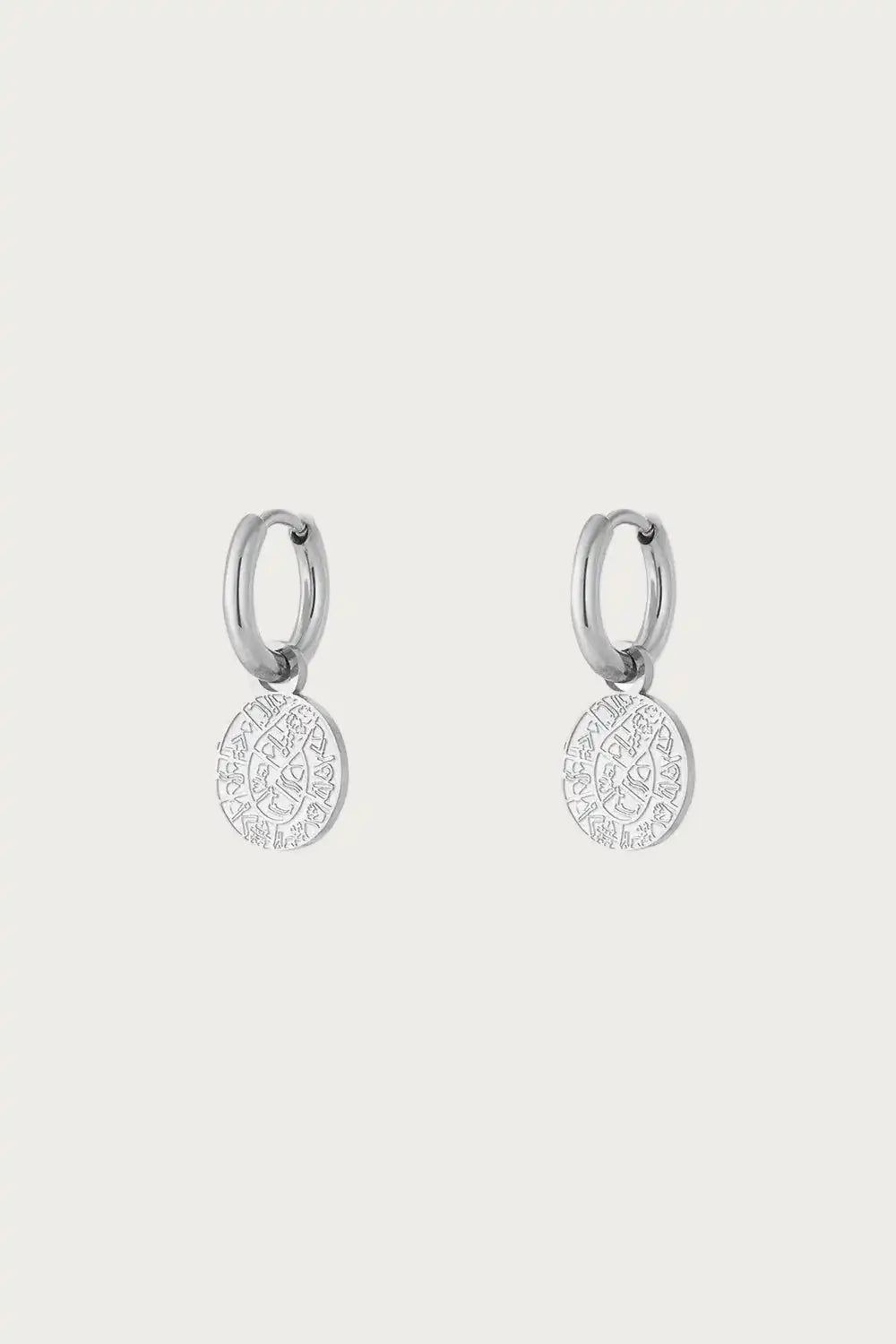Horoscope Coin Silver Oorbellen van Jewellery by Mae met zilverkleurige stainless steel hoops en subtiele horoscoopbedel. Tijdloos en stijlvol ontwerp.