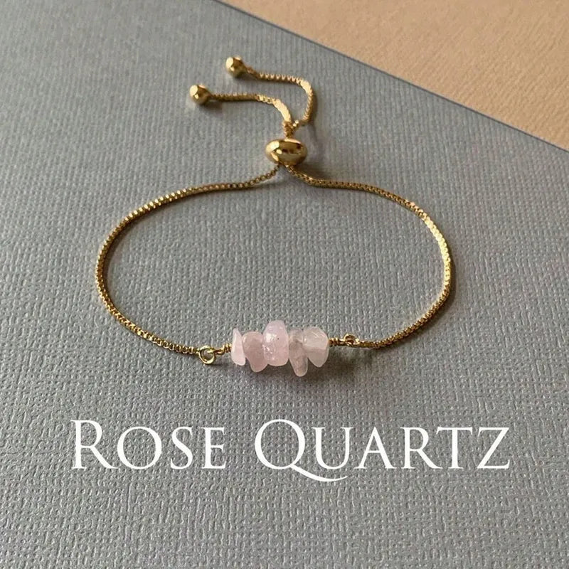 Gouden schakelarmband met onregelmatig gevormde rozenkwarts edelsteen kralen en verstelbaar sluitwerk.