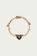 Donkerbruine gewoven armband met glimmende gouden kraaltjes en een hartjesbedel, verstelbaar.