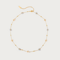 Gouden stainless steel ketting met lichtblauwe en witte bloemetjes en kleine gouden kraaltjes, sieraad.