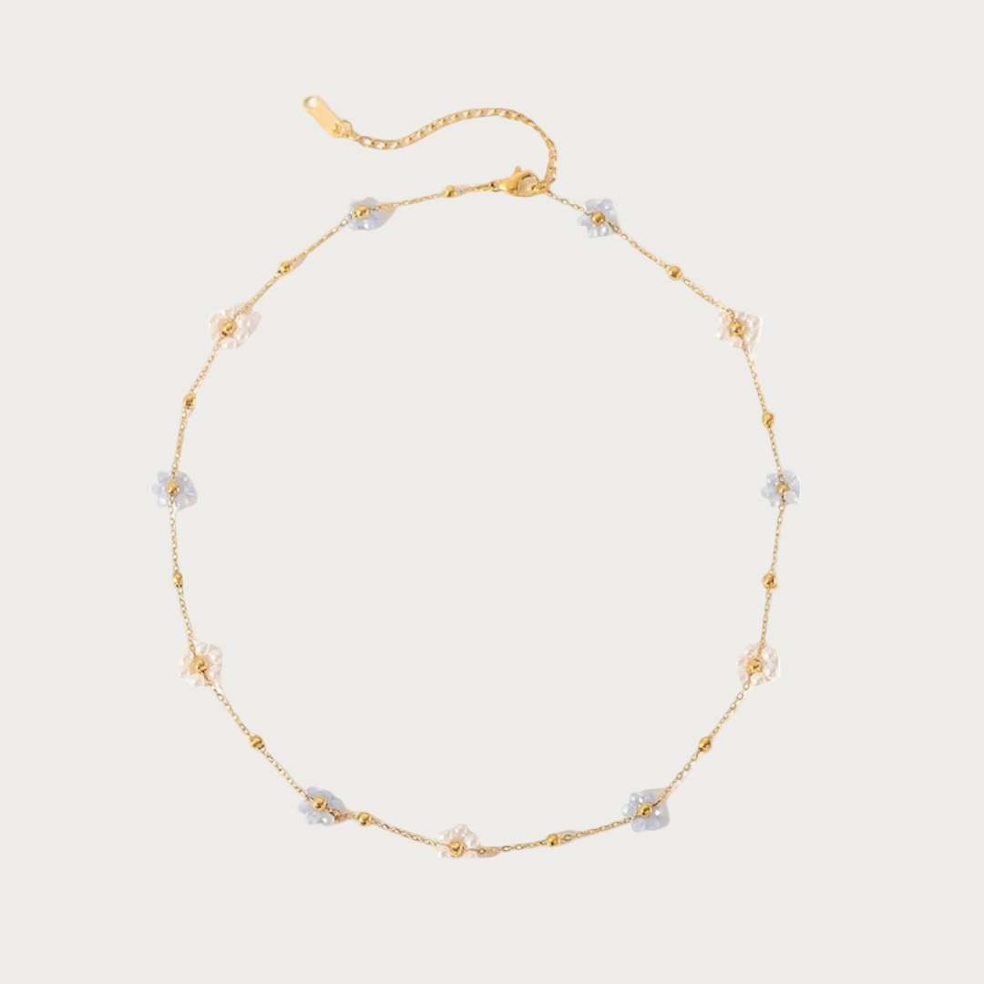 Gouden stainless steel ketting met lichtblauwe en witte bloemetjes en kleine gouden kraaltjes, sieraad.