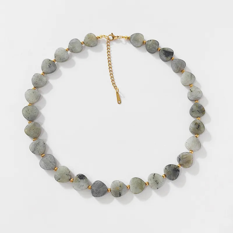 Elena hartvormige kralenketting van grijze stenen, gemaakt van stainless steel met gouden accenten en verstelbare sluiting.