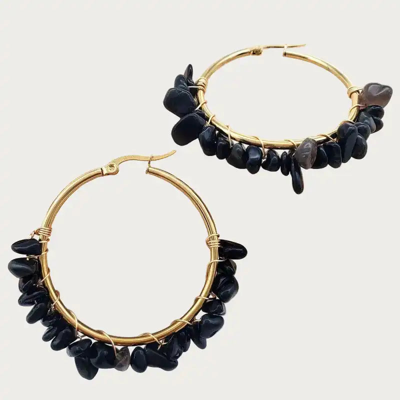 Paar gouden stainless steel oorbellen met glanzende zwarte obsidiaan natuursteen, wikkelontwerp