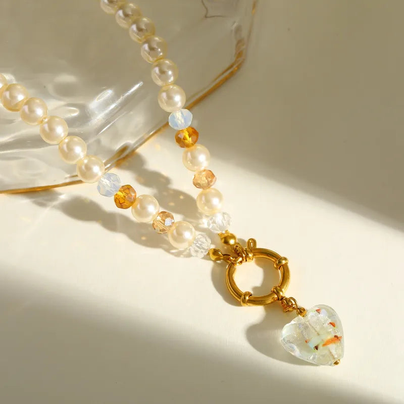 Elegante ketting met imitatieparels en gouden elementen, inclusief een hanger in de vorm van een glazen hartje