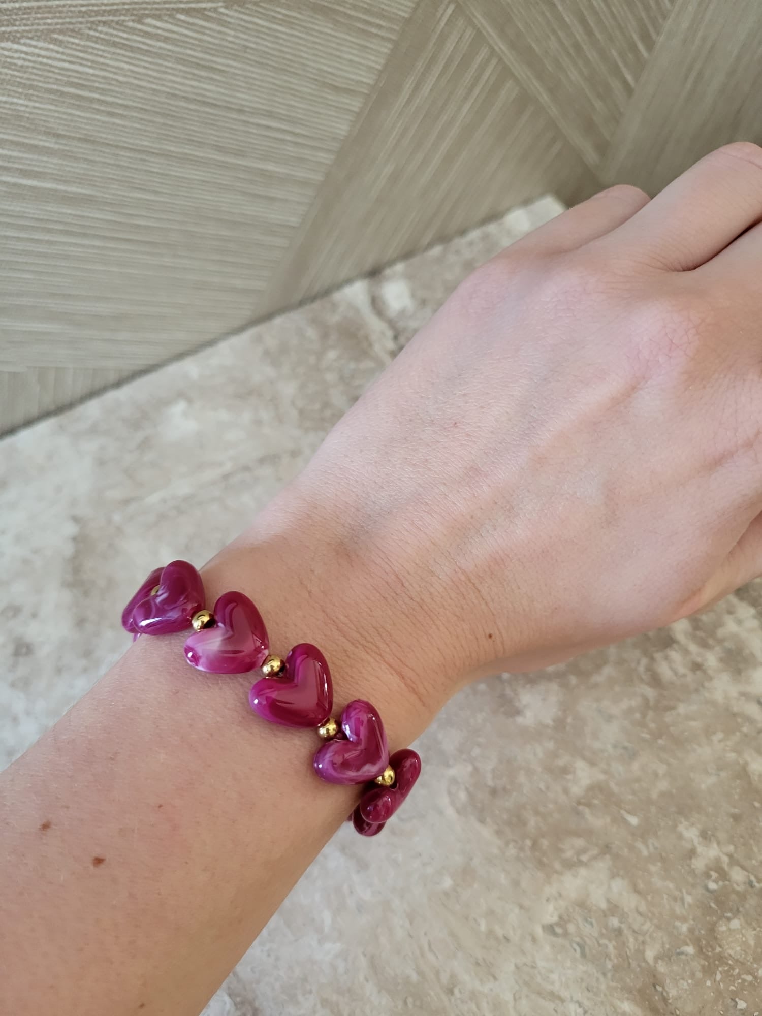 Milena hartjes armband met paarse stenen en gouden stainless steel accenten om een pols