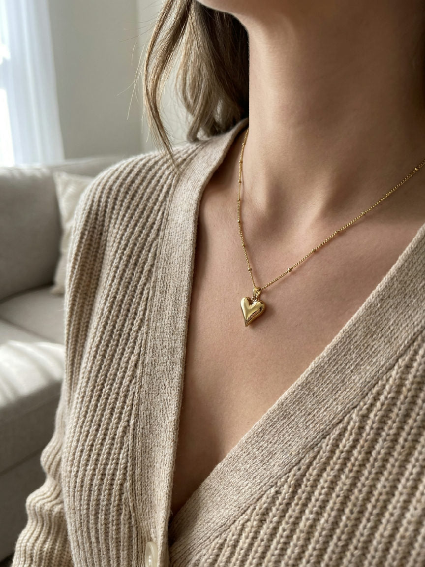 Gouden stainless steel hartjes ketting gedragen door vrouw met beige vest, elegant sieraad