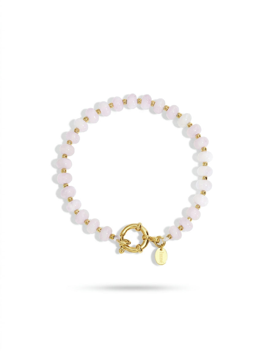 Eenvoudige lichtroze natuursteen kralen armband op een witte achtergrond, met de nadruk op de zachte kleur