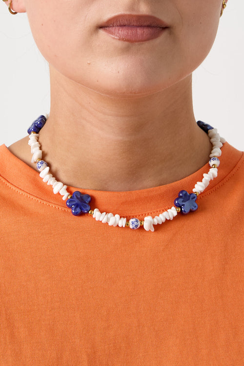 Ketting met stenen kralen, witte kralen met blauwe bloemetjes en statement bloemen