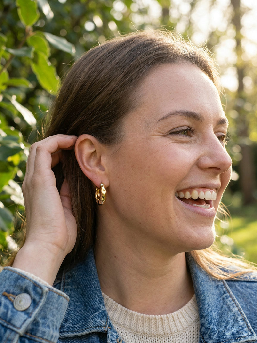 Elegante gouden oorringen, subtiel gebeeldhouwd, voegen een vleugje moderne klasse toe aan elke outfit
