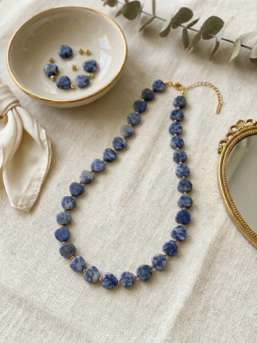 Elena hartvormige kralenketting van donkerblauwe natuursteen met gouden details, duurzaam RVS sieraad
