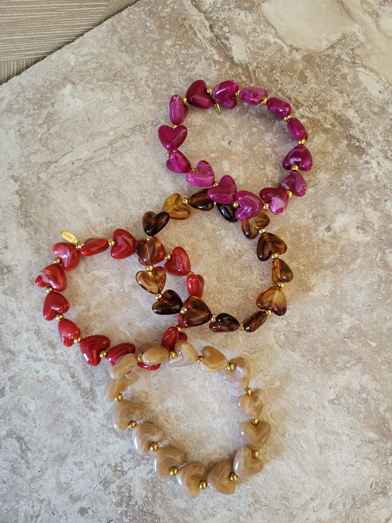 Milena hartjes armbanden in rood, bruin en roze met gouden accenten, gemaakt van roestvrij staal