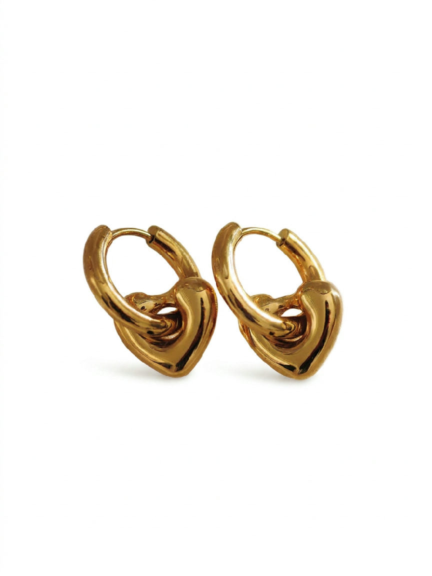 Gouden oorbellen in de vorm van een hartje, elegant en stralend op een minimalistische witte achtergrond