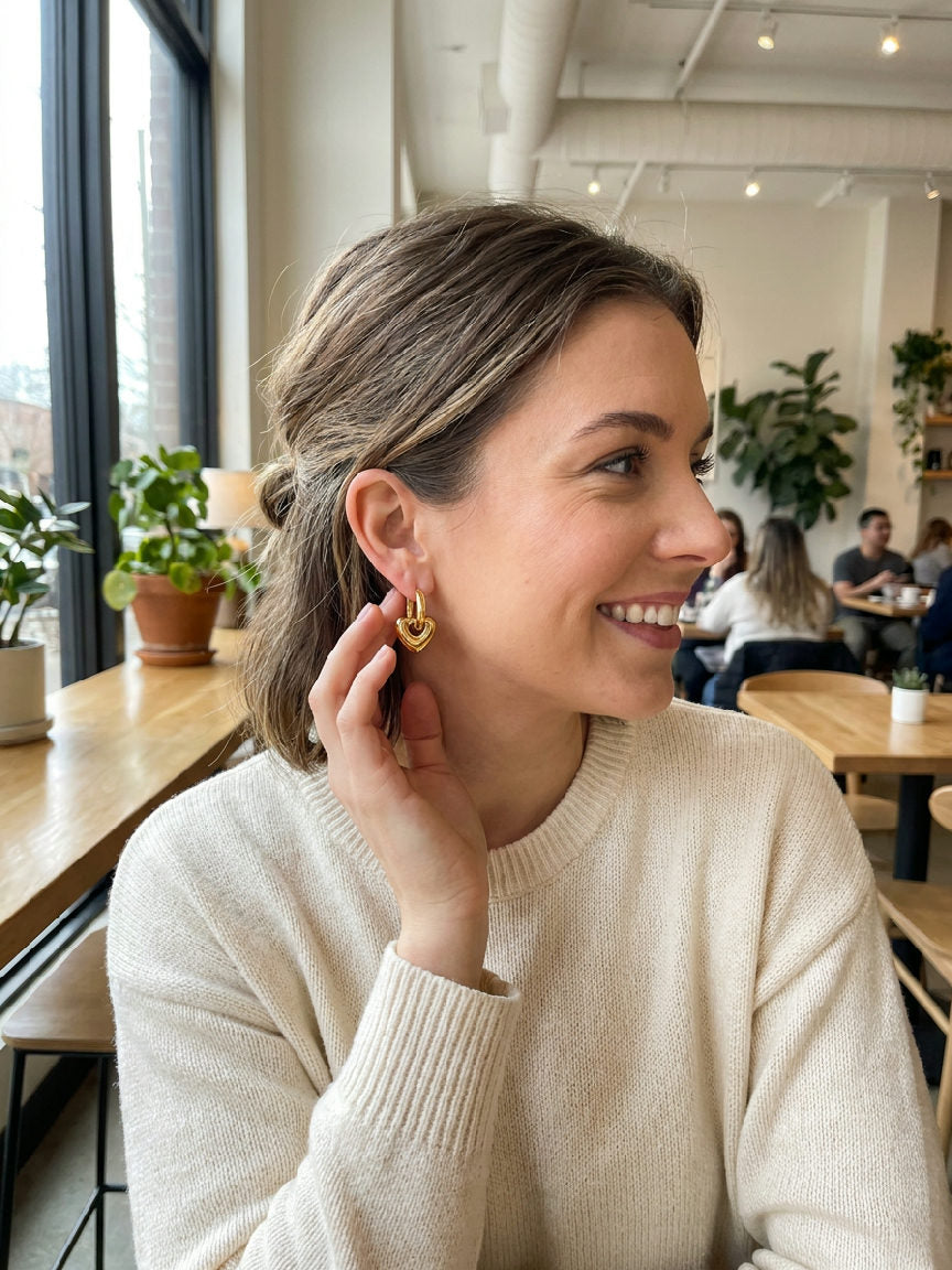 Gouden hartjesoorbellen van roestvrij staal, elegant gepresenteerd als stijlvol accessoire voor dagelijks gebruik
