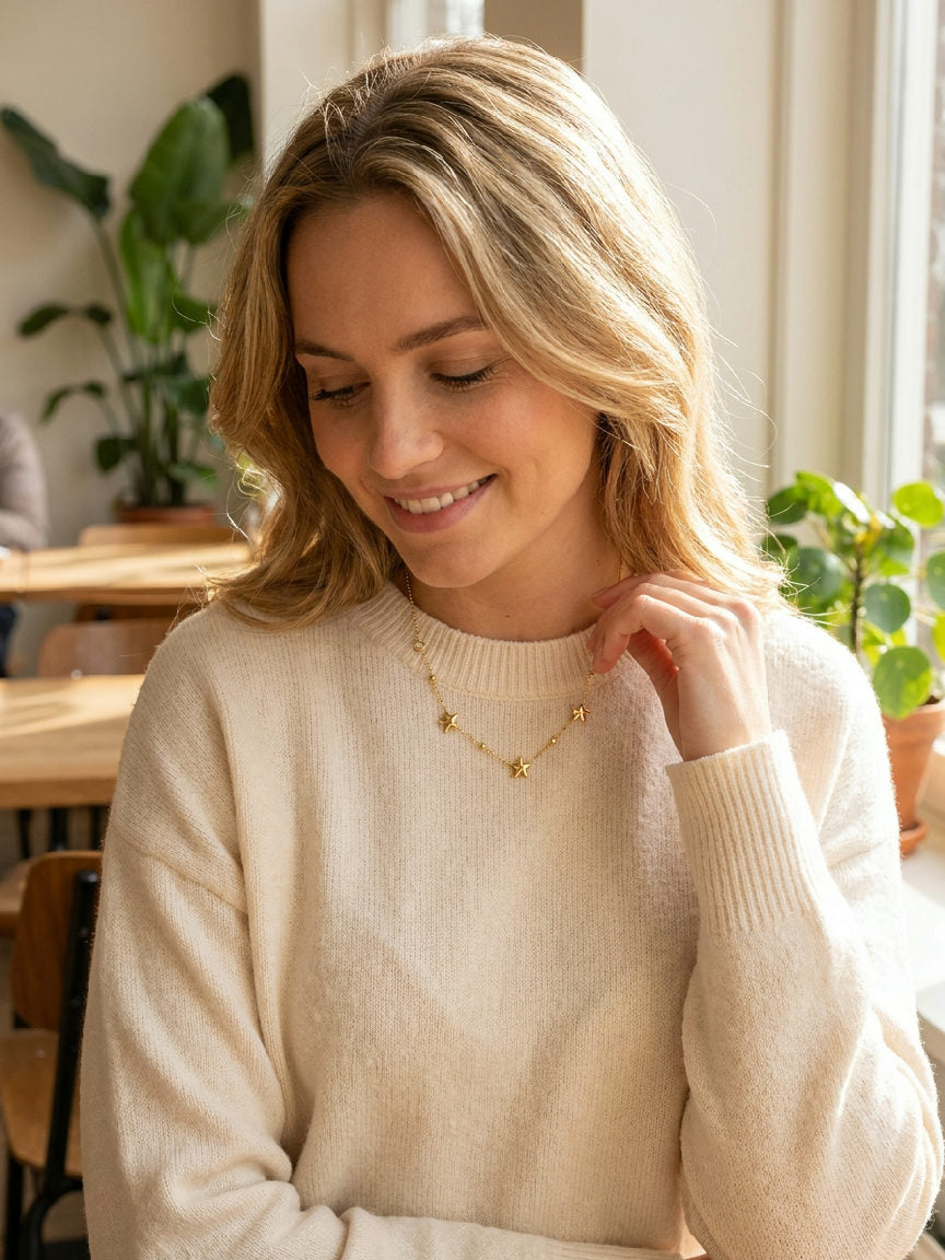 Elegante ketting met kleine zilverkleurige sterrenhangers en subtiele heldere steentjes, gedragen om de hals
