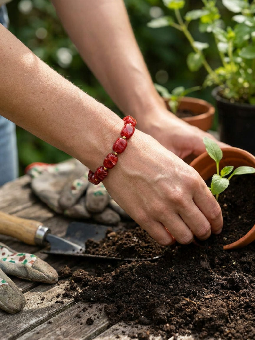 Ruby Red kralen armband van roestvrij staal, elegant gedragen door een vrouw in een lichte outfit, trendy accessoire