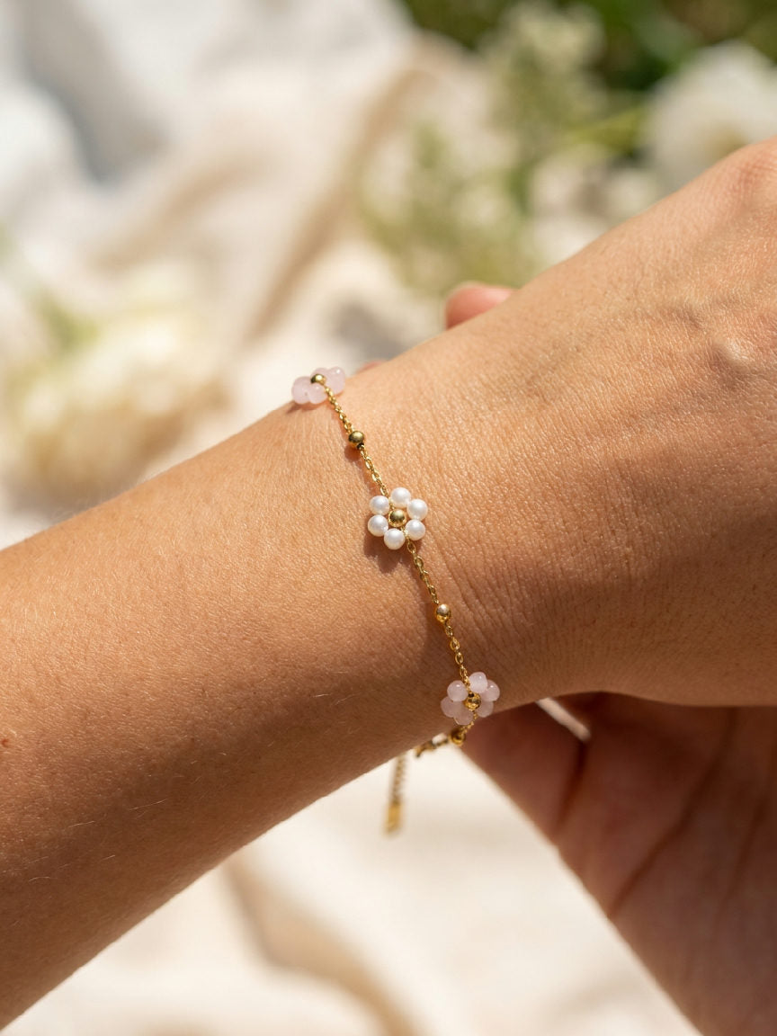 Elegante Miranda armband van roestvrij staal in een zachte lichtroze kleur, subtiel om de pols van een model, zomerse sfeer