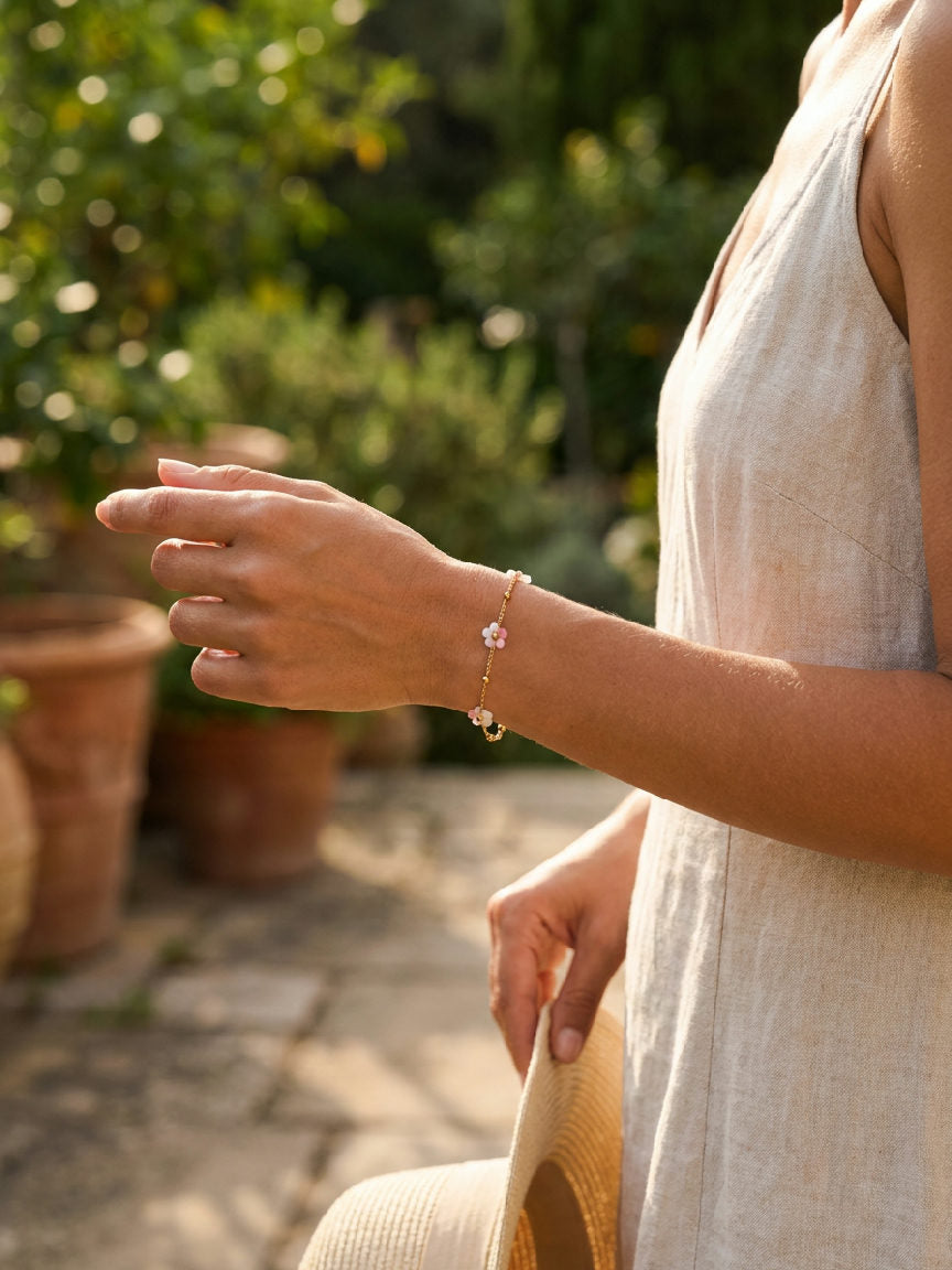 Roze roestvrijstalen Miranda armband om de pols van een model, schitterend in de zon, perfect voor de zomer