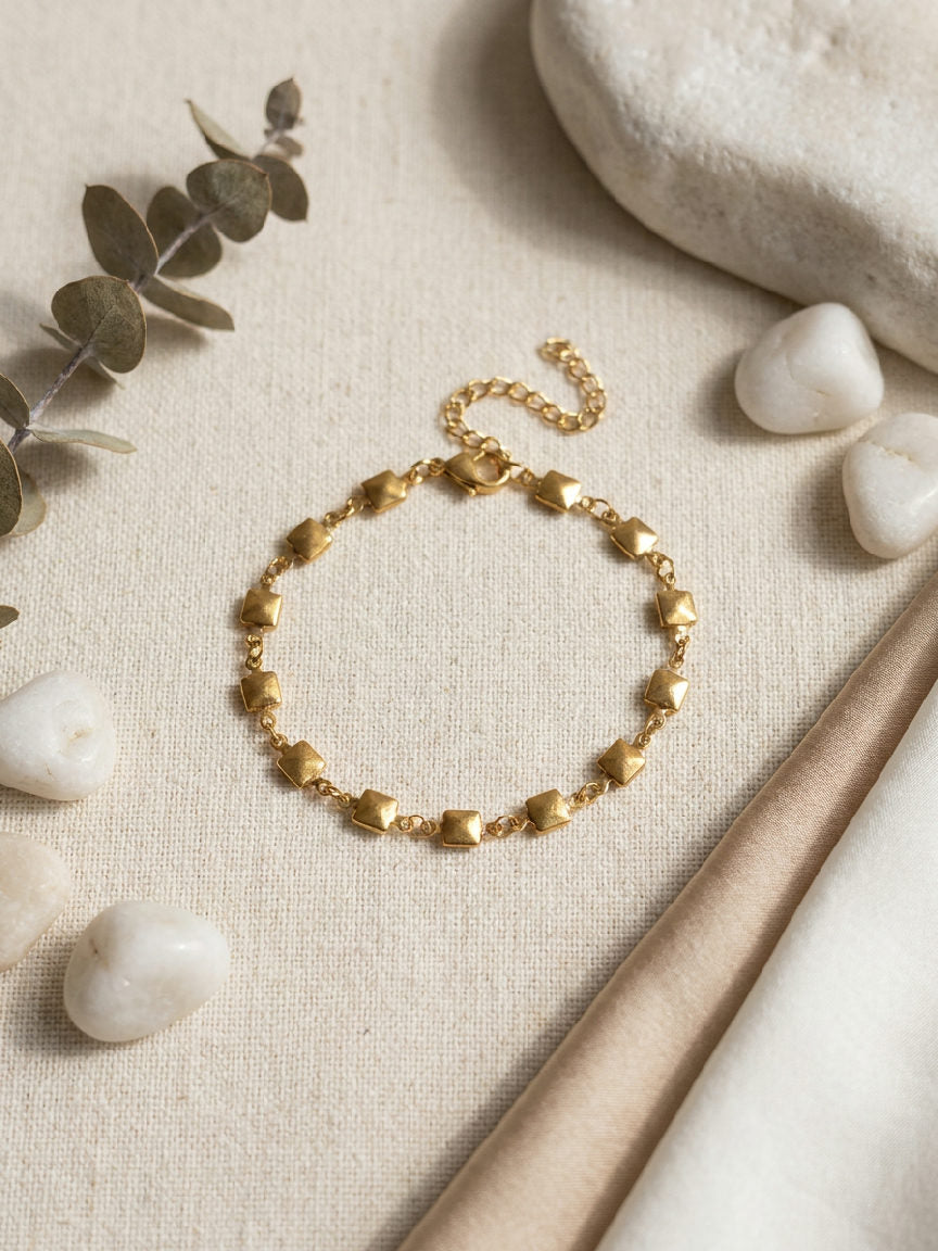 Glanzende roestvrijstalen Nola-armband platgelegd, met fijne schakels en een elegante sluiting, ideaal voor dagelijks gebruik
