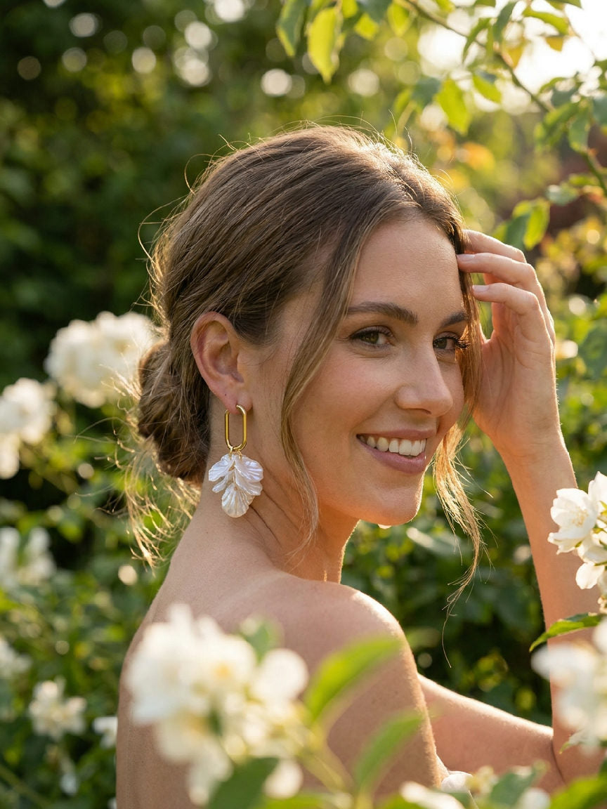 Elegante stainless steel oorringen met parels en bloemmotief, gedragen door een model, geschikt voor dagelijks gebruik.
