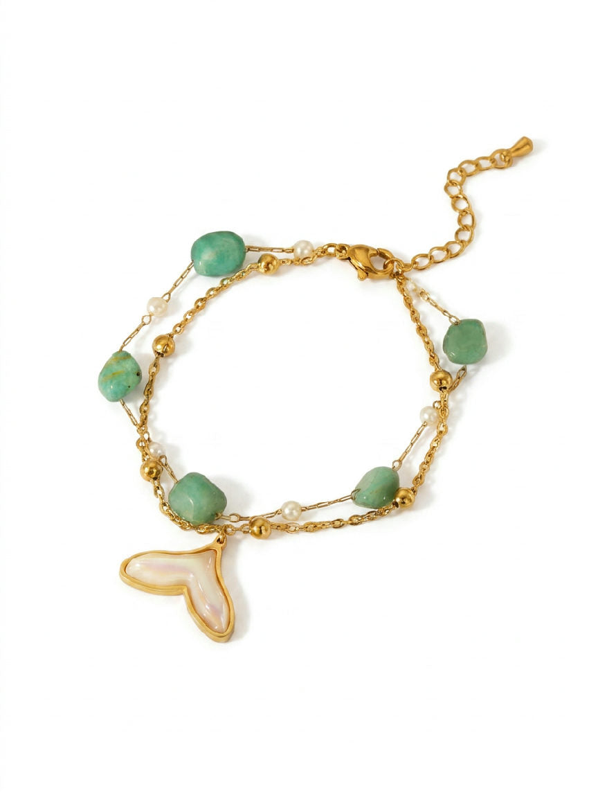 Een armband van roestvrij staal met een gedetailleerde walvisstaart als hanger, perfect voor maritieme liefhebbers.