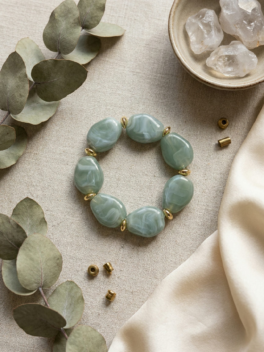 Squoval kralenarmband met grote lichtgroene squoval parels en gouden rvs kralen op een lichte achtergrond